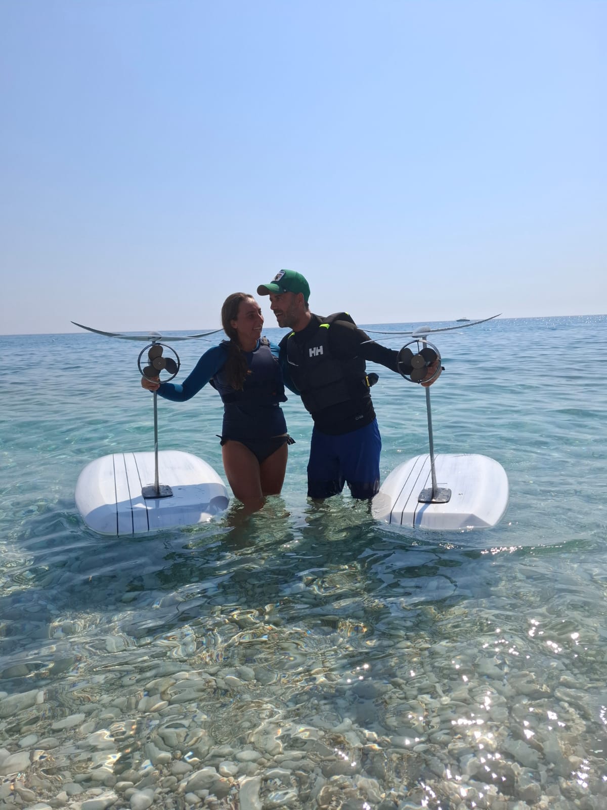 Couple standing in the Ionian holding their eFoil boards after a lesson