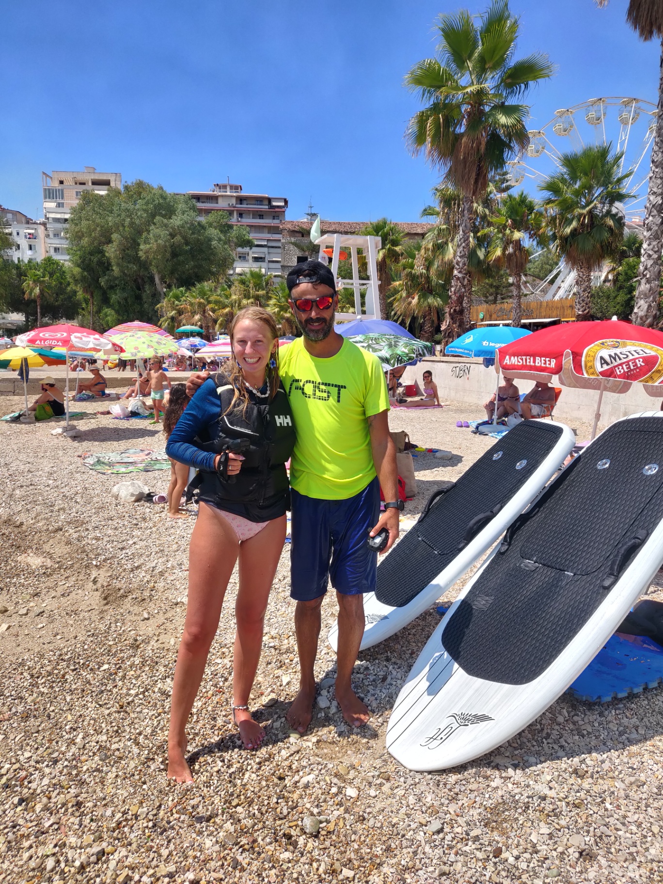 Founder portrait with a happy student and boards on the beach