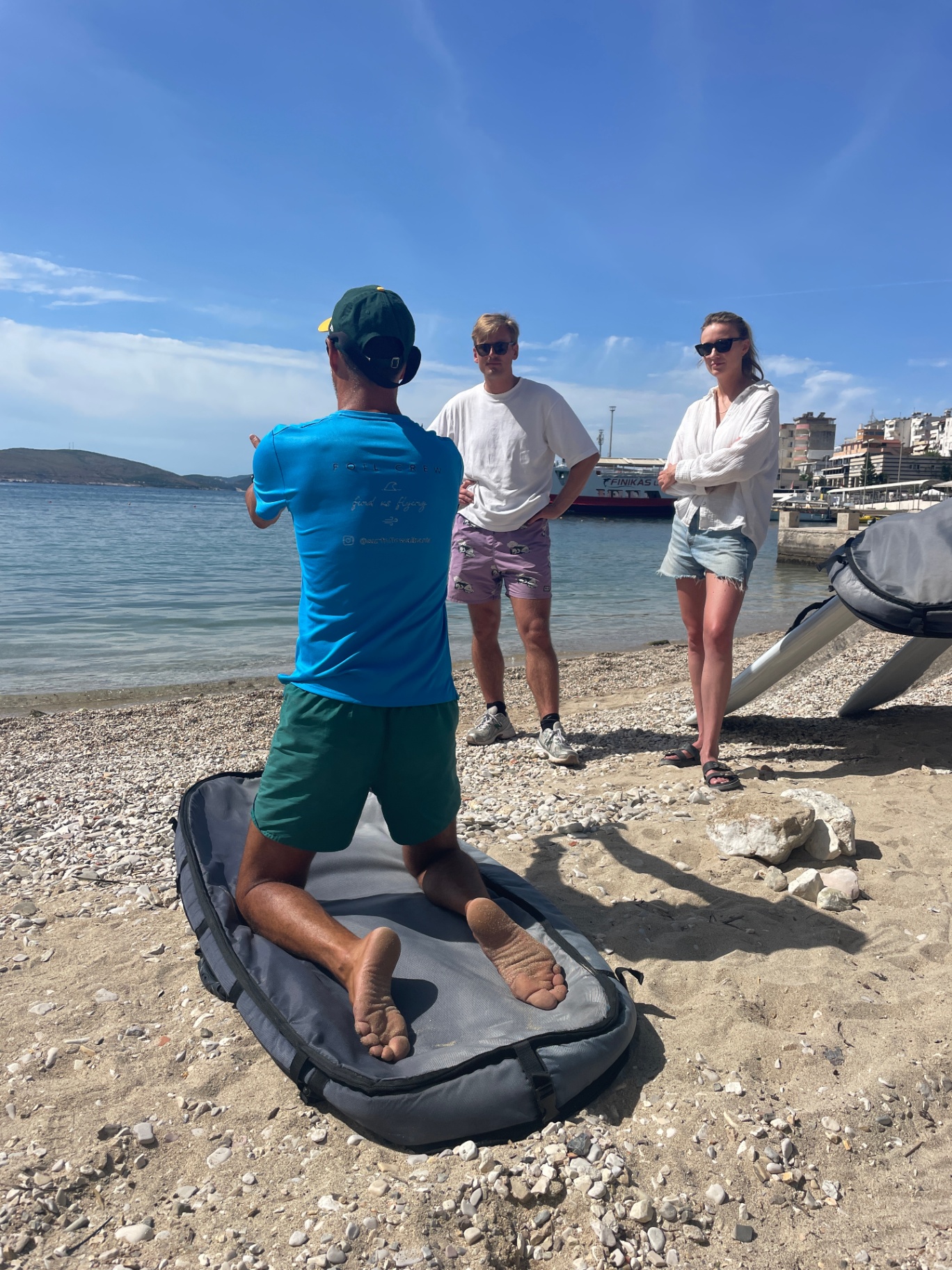 Instructor demonstrating foil board positioning to students on the beach