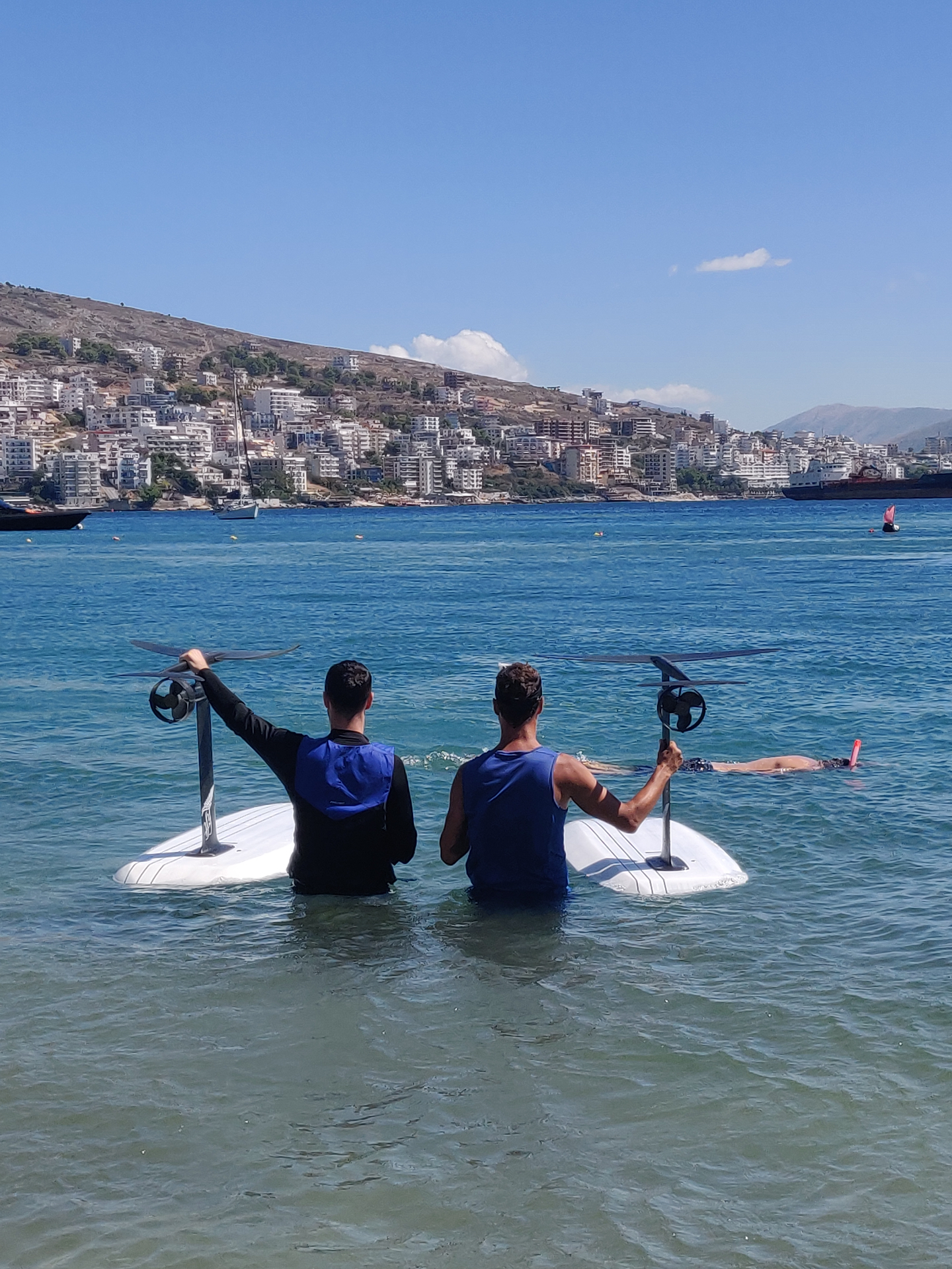 eFoil lesson in Sarandë bay with riders walking boards into the Ionian