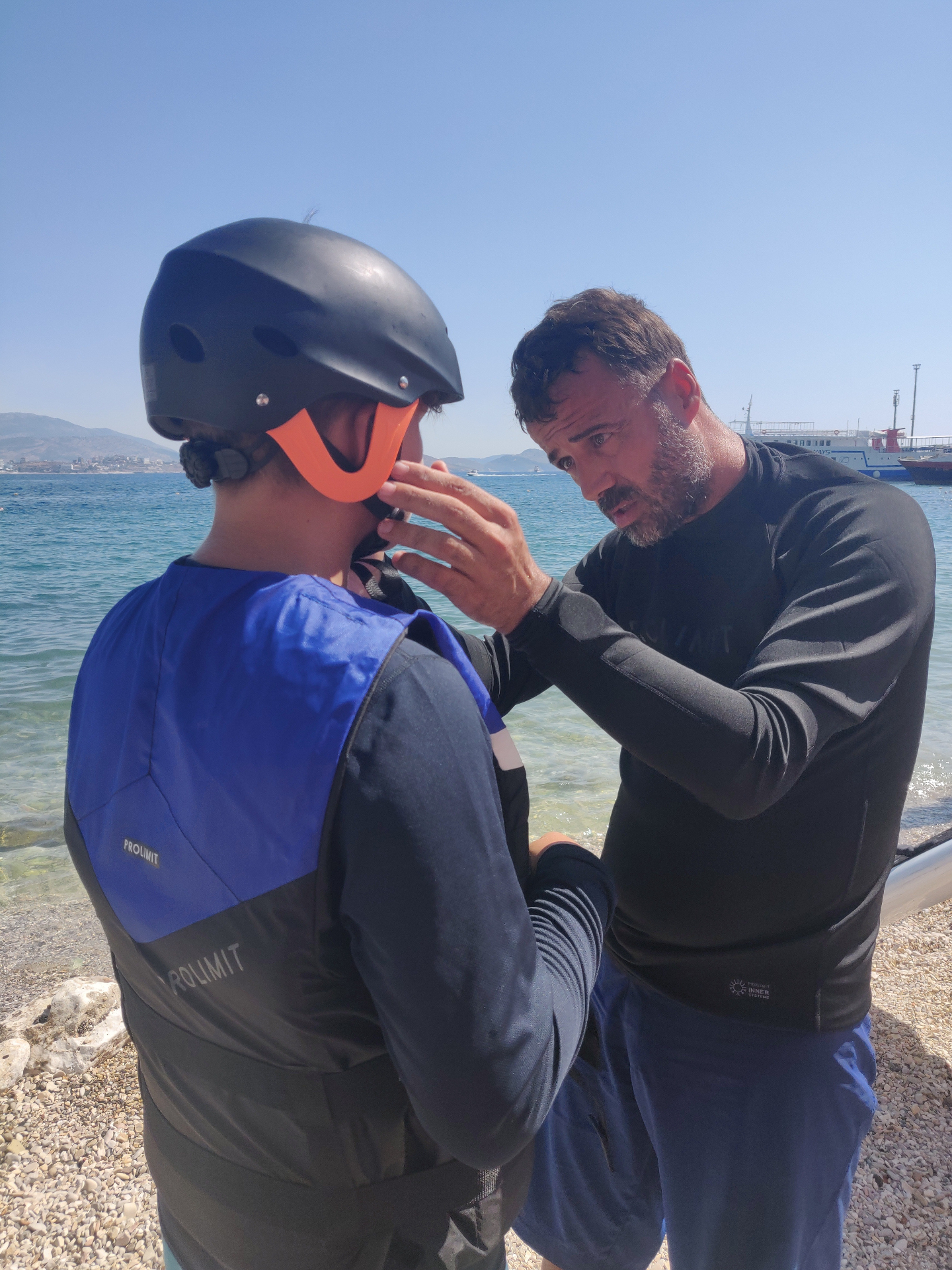 Instructor fitting a helmet for a student before an eFoil lesson